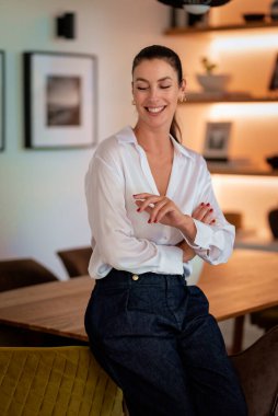 Dairesinde durup gülümseyen güzel bir kadının portresi. Orta yaşlı kadın günlük kıyafetler giyiyor..