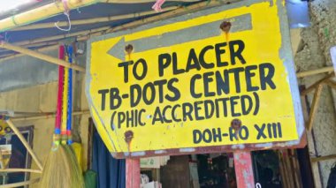 Placer, Surigao Del Norte, Filipinler 'de bulunan tabela, tüberkülozun tedavi ve önlenmesine adanmış bir tıp merkezine ev sahiplerini ve ziyaretçileri yönlendiriyor. Bu işaret erişilebilir sağlık hizmetlerinin önemini vurgular.