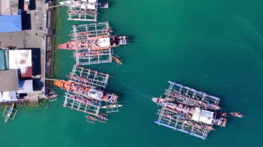 Placer, Surigao Del Norte 'ye demirlemiş pompa ve banca teknelerinin insansız hava aracı görüntüsü güneşli bir günde adalar ve anakara arasındaki yerel ulaşımı gösteriyor..
