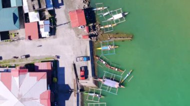 Güneşli gün kuşları, Placer, Surigao Del Norte 'ye demirlemiş pompa ve banka teknelerinin hava aracı görüntülerini izleyerek adalar ve anakara arasındaki temel ulaşım bağlantılarını vurguluyor..