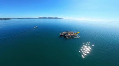 Filipinler 'in parlak renkli uzun menzilli balıkçı teknelerini çeken dikey FPV video görüntüleri. Placer, Surigao Del Norte, Kuzey Mindanao' da açık mavi gökyüzünün altında demirlemiş..