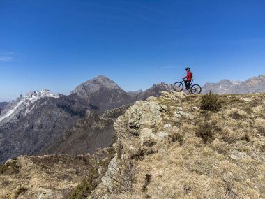 Dağ bisikletçisi su di una vetta delle Alpi Apuane in un giorno di primavera in Alta Versilia, Toscana.
