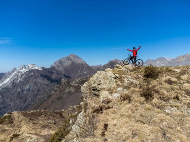 Dağ bisikletçisi su di una vetta delle Alpi Apuane in un giorno di primavera in Alta Versilia, Toscana.