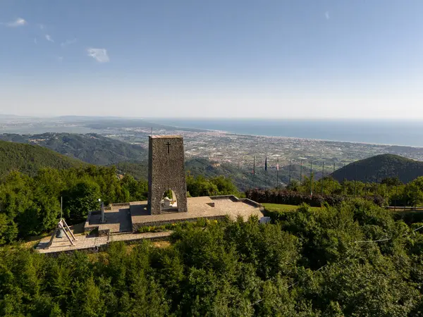 stock image Sant'Anna di Stazzema, Italy - Jul 16 2024: the Memorial Ossuary monument to the victims of the Nazi-fascist massacre and Versilia's coast view