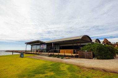 Güney Avustralya, Avustralya 'da güneşli bir sonbahar gününde Granite Island Recreation Park ve Victor Harbor' daki kafe binasını geziyor.