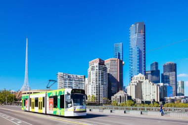 MELBOURNE, AUSTRALYA - 31 Ekim 2021: Melbourne CBD ve Princes Köprüsü 'ne doğru Melbourne, Victoria, Avustralya' daki Yarra Nehri boyunca bir tramvayla görüntüleniyor