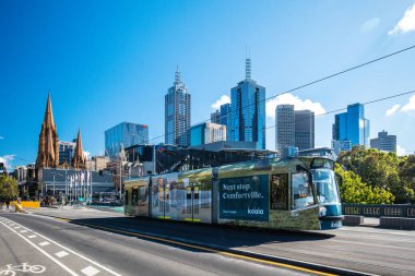 MELBOURNE, AUSTRALYA - 31 Ekim 2021: Melbourne CBD ve Princes Köprüsü 'ne doğru Melbourne, Victoria, Avustralya' daki Yarra Nehri boyunca bir tramvayla görüntüleniyor