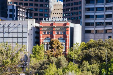 MELBOURNE, AUSTRALIA - 31 Ekim 2021: Melbournes 'in CBD' nin doğu ucu ve Birrarung Marr 'dan ikonik Hotel Lindrum Binası' nın ufuk çizgisi Victoria, Avustralya 'da güneşli bir bahar sabahı