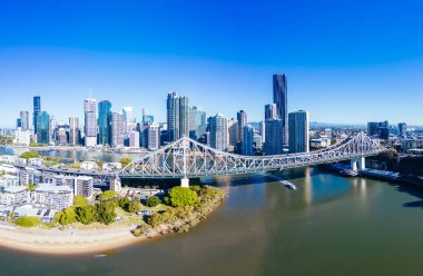 Avustralya, Queensland 'da güneşli bir kış sabahı, New Farm ve Wilson Outlook Reserve banliyölerinden Brisbane ufuk çizgisine ve Story Bridge' e yüksek irtifa manzarası.