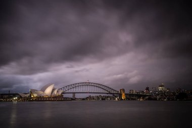 SYDNEY, AUSTRALIA - 3 Aralık 2023: Sydney Opera Binası ve Liman Köprüsü, Sydney, New South Wales, Avustralya 'daki Bayan Macquaries' in yaz fırtınası sırasında