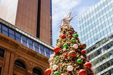 SYDNEY, AUSTRALYA 3 Aralık 2023: Sidney CBD, New South Wales, Avustralya 'da yoğun bir günün ortasında Noel ağacı, ışıkları ve süslemeleri olan Martin Place