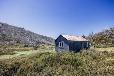 Schlink Geçidi yakınlarındaki Kosciuszko Ulusal Parkı 'ndaki tarihi Beyaz Nehir Kulübesi açık bir yaz gününde, Yeni Güney Galler, Avustralya' daki Karlı Dağlar 'da