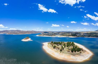 Yeni Güney Galler 'de sıcak bir yaz gününde Jindabyne Gölü' ndeki Aslan ve Cub Adaları üzerindeki Jindabyne kasabası manzarası.