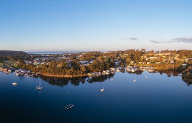 Gün batımında Narooma 'nın huzurlu sahil kasabasının havadan görünüşü Güney Sahili, Yeni Güney Galler, Avustralya' daki ünlü Wagonga Körfezi 'nin etrafını sardı.