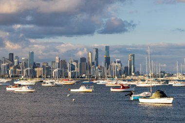 Melbourne silueti Hobsons Körfezi boyunca Williamstown rıhtımındaki Ferguson St Pier 'den kışın Victoria, Avustralya' da alacakaranlıkta yükseliyor.