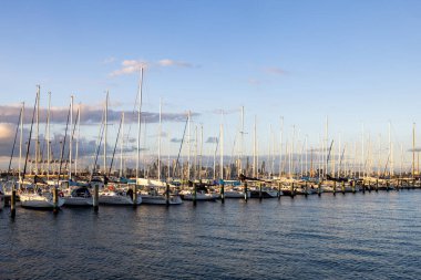 Melbourne silueti Hobsons Körfezi boyunca Williamstown rıhtımındaki Ferguson St Pier 'den kışın Victoria, Avustralya' da alacakaranlıkta yükseliyor.