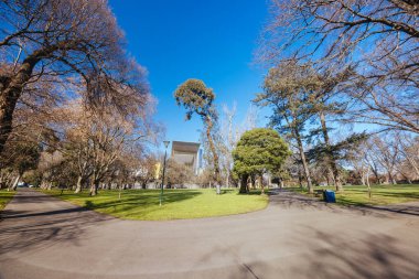 Melbourne Avustralya 'da Melbourne Müzesi' nin arka planında açık güneşli bir kış gününde Carlton Gardens