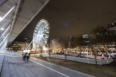 MELBOURNE, AUSTRALIA - 5 Temmuz 2024: Polly Woodside Park ve dönme dolap ve Melbourne silueti Melbourne Sergi Merkezi 'nden alacakaranlıkta görüldüğü gibi