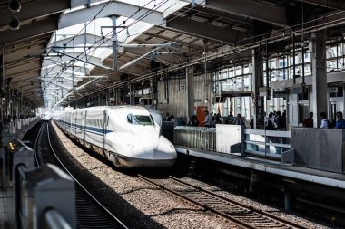 KYOTO, JAPAN - MAY 13, 2019: A Shinkansen high-speed bullet train pulling into a train station in Japan clipart