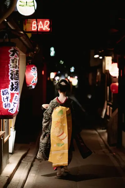 stock image KYOTO, JAPAN - MAY 17, 2019: A Geisha wallks down Pontocho Alley at night in central Kyoto, Japan