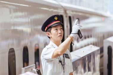 KYOTO, JAPONYA - 24 EPTEMBER 2024: Kyoto tren istasyonu personeli Kyoto, Japonya 'daki bir Shinkansen hızlı treninin tren durağında rutinleri sırasında