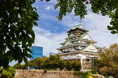 OSAKA, JAPONYA - 25 Eylül 2024 'te Japonya' nın Osaka kentinde sıcak bir sonbahar gününde ikonik Osaka Kalesi ve yemyeşil çevre