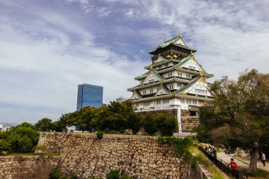 OSAKA, JAPONYA - 25 Eylül 2024 'te Japonya' nın Osaka kentinde sıcak bir sonbahar gününde ikonik Osaka Kalesi ve yemyeşil çevre