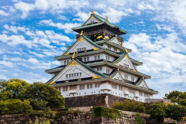 OSAKA, JAPONYA - 25 Eylül 2024 'te Japonya' nın Osaka kentinde sıcak bir sonbahar gününde ikonik Osaka Kalesi ve yemyeşil çevre