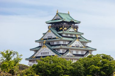OSAKA, JAPONYA - 25 Eylül 2024 'te Japonya' nın Osaka kentinde sıcak bir sonbahar gününde ikonik Osaka Kalesi ve yemyeşil çevre