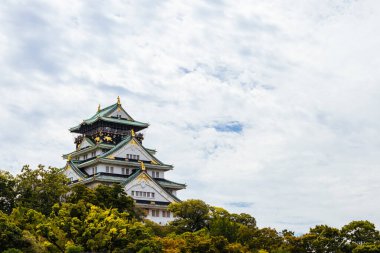 OSAKA, JAPONYA - 25 Eylül 2024 'te Japonya' nın Osaka kentinde sıcak bir sonbahar gününde ikonik Osaka Kalesi ve yemyeşil çevre