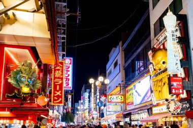 OSAKA, JAPONAN - 25 Eylül 2024: Osakas 'ın ünlü Dotonbori bölgesi ve birçok restoranı ve ikonik gıda işareti ile Japonya' nın Osaka kentinde alacakaranlıkta