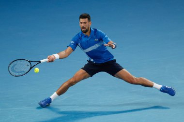 MELBOURNE, AUSTRALIA - 19 Ocak 2025 'te Melbourne Park' ta oynanan 2025 Avustralya Açık 'ın sekizinci gününde Sırp Novak Cokoviç forehand vuruyor