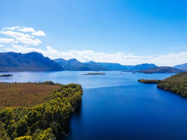 Lake Burbury and surrounding mountain landscape on a warm summers aftenoon near Queenstown in Tasmania, Australia clipart