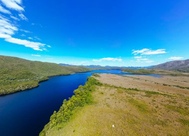 Lake Burbury and surrounding mountain landscape on a warm summers aftenoon near Queenstown in Tasmania, Australia clipart