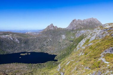 Cradle Mountain, Tazmanya, Avustralya 'da sıcak bir sonbahar sabahında Dove Gölü' nden Hansons Tepesi ve Cradle Dağı 'na doğru dağ manzarası.