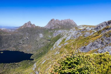 Cradle Mountain, Tazmanya, Avustralya 'da sıcak bir sonbahar sabahında Dove Gölü' nden Hansons Tepesi ve Cradle Dağı 'na doğru dağ manzarası.