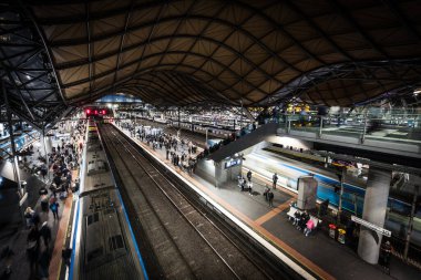 MELBOURNE, AUSTRALYA - 25 Temmuz 2025: Melbourne, Victoria, Avustralya 'daki Güney Haç İstasyonu' nda akşam trafiği sırasında yolcuların ve trenlerin genel şehir manzarası