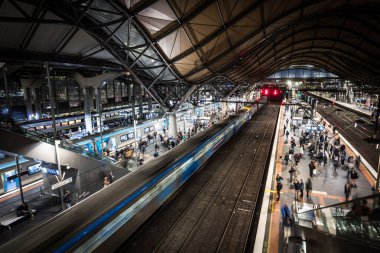 MELBOURNE, AUSTRALYA - 25 Temmuz 2025: Melbourne, Victoria, Avustralya 'daki Güney Haç İstasyonu' nda akşam trafiği sırasında yolcuların ve trenlerin genel şehir manzarası