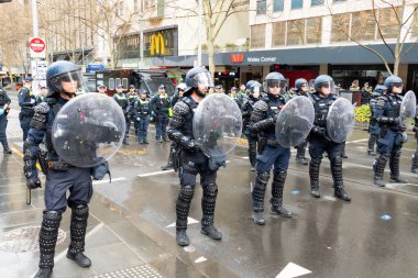 MELBOURNE, AUSTRALIA - 31 Ağustos 2025: Göçmenlik karşıtı protestocular ve karşı protestocular 31 Ağustos 2025 'te Melbourne, Victoria, Avustralya' da çatışırken çevik kuvvet polisi tetikte bekliyor.