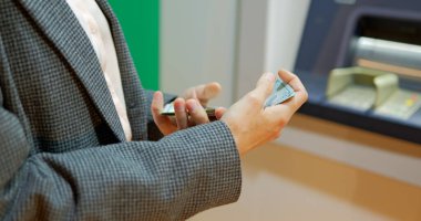 Gece ATM 'nin yanında kadın eli dolar taşıyor. Kız para çekiyor. Yüksek kalite fotoğraf