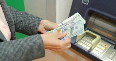 Gece ATM 'nin yanında kadın eli dolar taşıyor. Kız para çekiyor. Yüksek kalite 4k görüntü