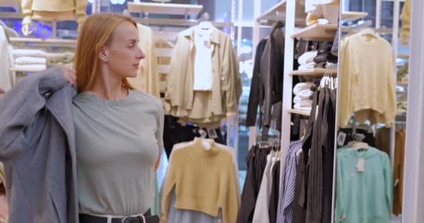 Леди Примеряет Модное Современное Пальто Магазине Одежды Торговом Центре Клиент — стоковое видео