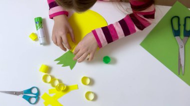 Çocuk renkli kağıt ve yapıştırıcıyla bir cihaz yapıyor. Hobi ve eğitim kavramı. Yüksek kalite fotoğraf