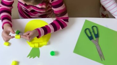 Çocuk renkli kağıt ve yapıştırıcıyla bir cihaz yapıyor. Hobi ve eğitim kavramı. Yüksek kalite 4k görüntü