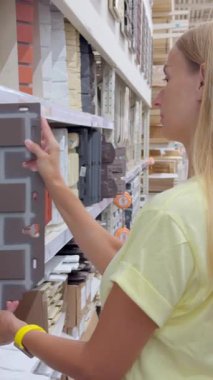 Ev dekorasyonu mağazasındaki dekoratif duvar panellerini inceleyen bir kadın. Yüksek kalite 4k görüntü