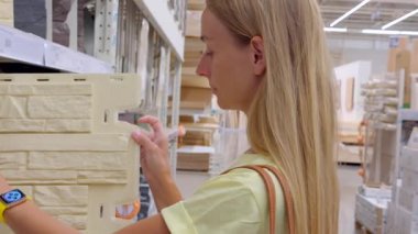 Ev dekorasyonu mağazasındaki dekoratif duvar panellerini inceleyen bir kadın. Yüksek kalite 4k görüntü