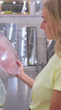 Müşteri Ev Malzemeleri Mağazasında Duvar Saati Seçiyor. Yüksek kalite dikey 4k görüntü