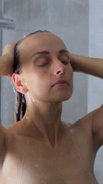 Genç bayan ferahlatıcı duşun tadını çıkarıyor. Yüksek kalite 4k görüntü