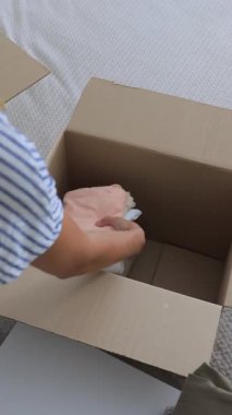Kadın eşyaları karton bir kutuya koyuyor. Yüksek kalite 4k görüntü