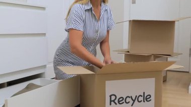 Evde kıyafetleri geri dönüşüm kutusuna sıralayan bir kadın. Yüksek kalite 4k görüntü